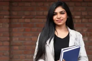 Jovem com livros — artigo sobre o impacto de longo prazo da miopia